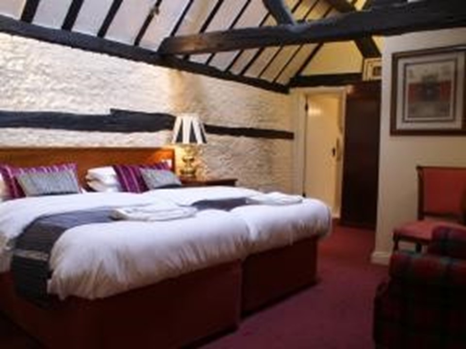 Twin room with exposed Tudor beams and whitewashed walls